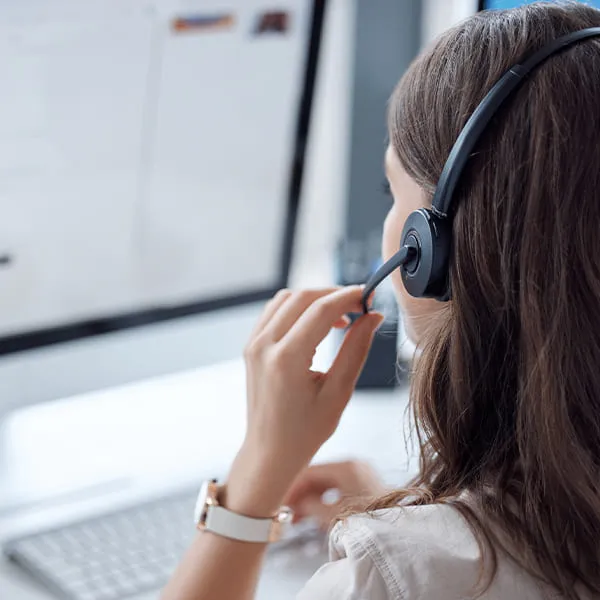 Mujer con auriculares en su computadora mientras rastrea paquete